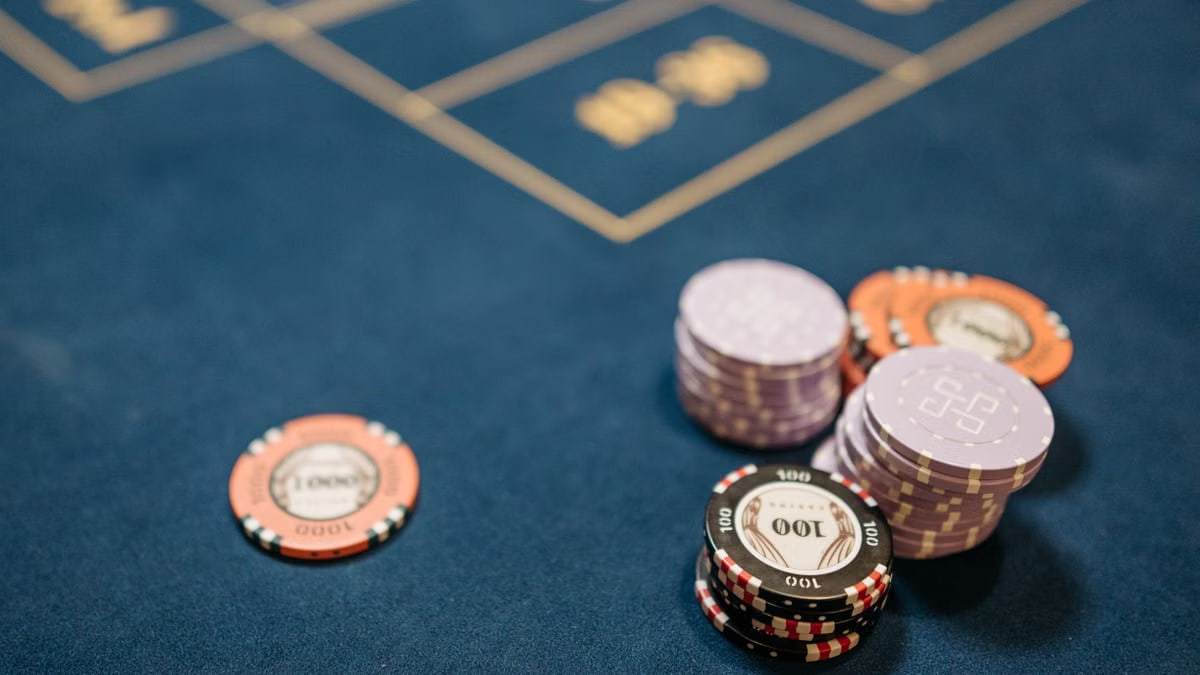 A detailed view of poker chips on a blue gaming table, perfect for gambling themes.